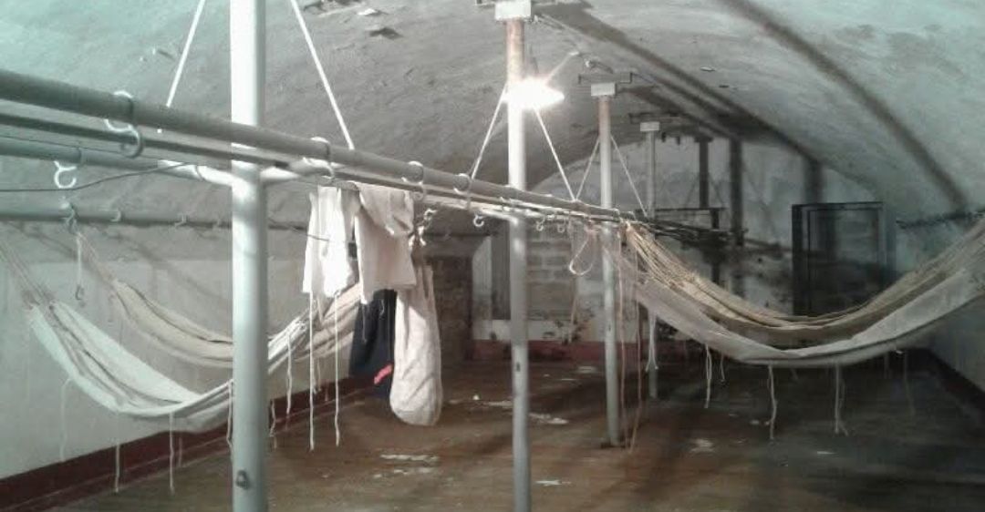 Casemate voûtée avec des hamacs de toile suspendus à des barres métalliques