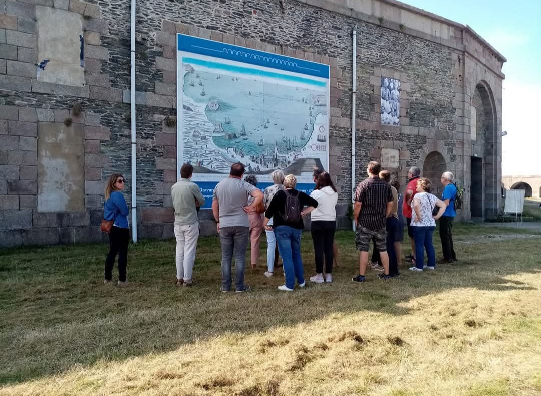 Groupe de visiteurs devant un panneau d'interprétation illustrant la rade de Cherbourg